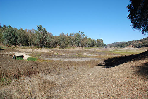 There are two bridges that were flooded with the filling of the reservoir. This bridge can be seen right now.(November 1, 2014). It is near the south end of the reservoir. Park near the present day intersection of the Old Santa Cruz Highway and Wrights Drive and carefully make your way to the reservoir. You can't miss it.