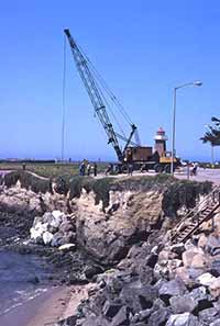 A crane placing rip-rap near Steamer Lane in 1981. Photo courtesy of and © Frank Perry.