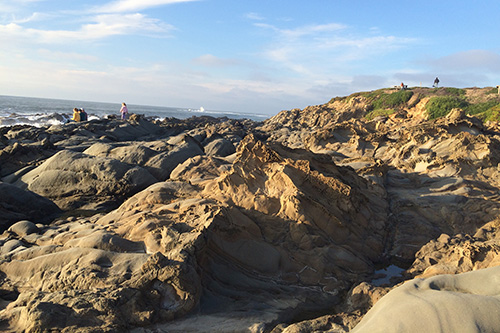 Pebble Beach with some tafoni in the Quaternary sandstone.