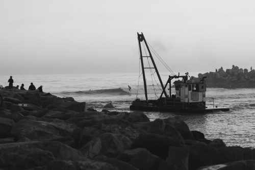 Harbor surfing. Careful dude, don't hit the dredge. Photo: Crystal Birns Photography