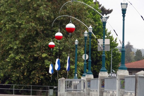‘Fishing Rods’ created by Nielsen Design Studios hangs off of the Water St. Bridge. This is one of ten installations created for the Ebb & Flow River Arts Project in June 2015. Photo courtesy and © of Nick Ibarra.